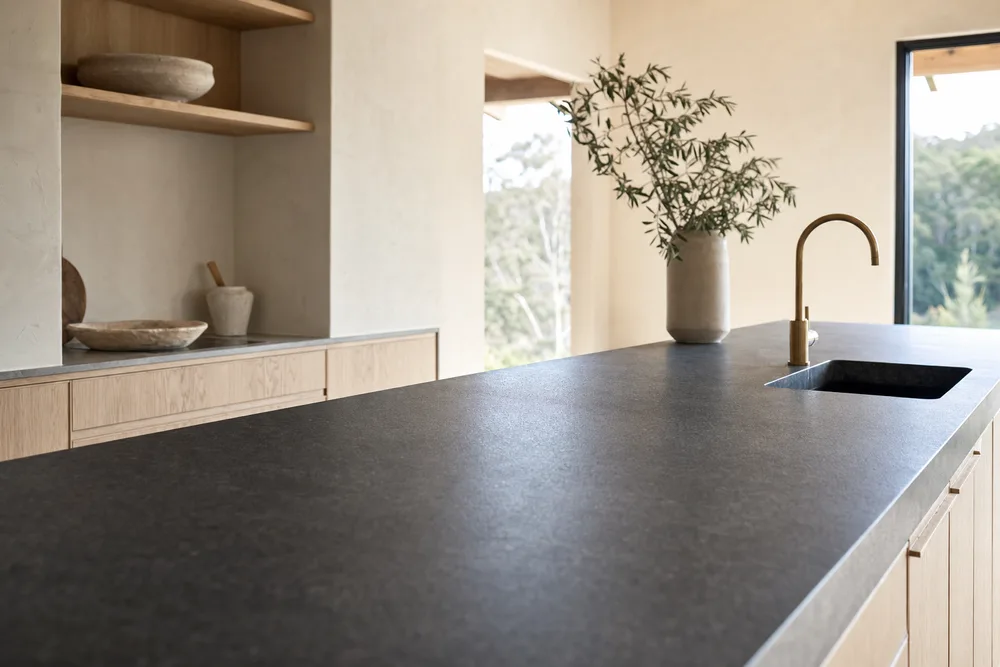Honed charcoal stone benchtop in a light timber kitchen