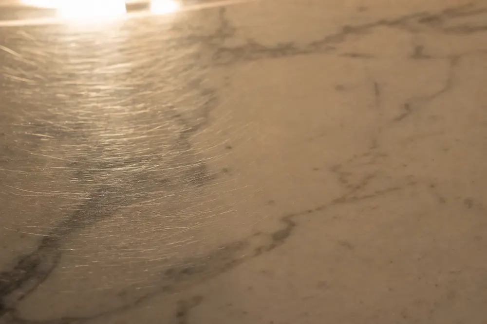 Fine swirl scratches in the clear film fading away to a perfectly smooth surface