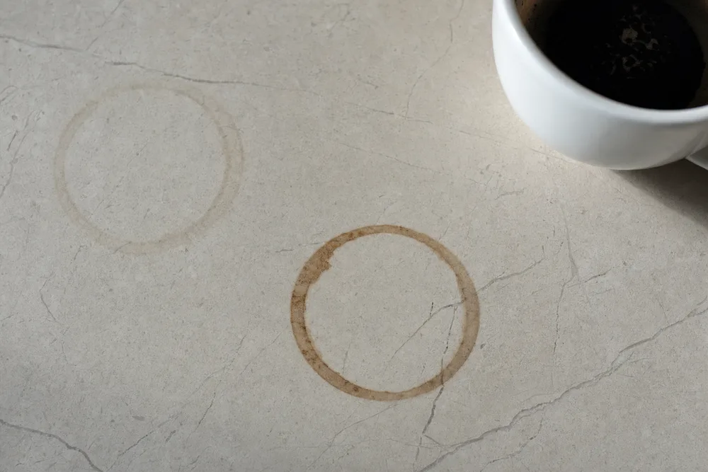 A dried coffee ring soaked into a honed marble benchtop
