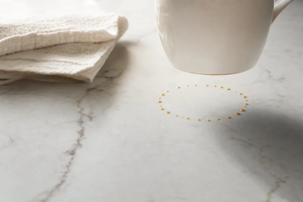 Coffee droplets sitting on top of filmed marble with no ring in the stone