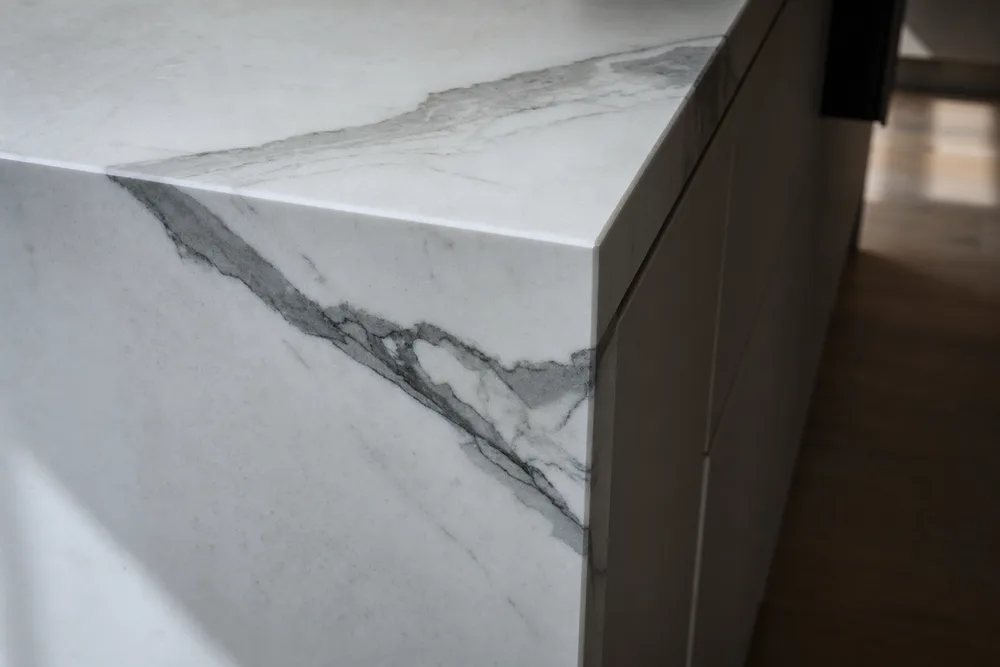 Mitred waterfall-edge corner in grey-veined marble