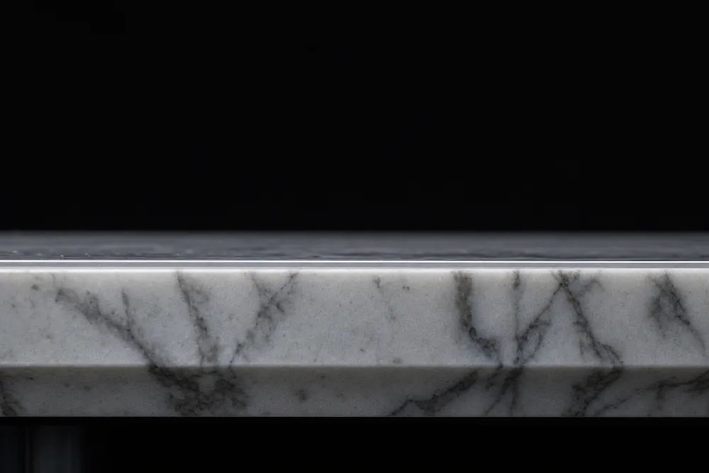 Side view of a marble slab with an ultra-thin clear protective film catching the light along its top surface